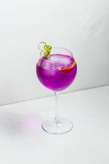 Unusual purple alcoholic cocktail in a wine glass