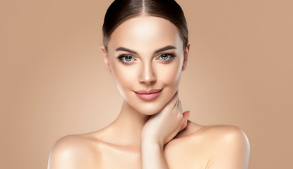 Beautiful young woman with clean fresh skin touching her face . Girl facial  treatment   ....