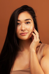 Fototapeta premium young pretty asian woman cheerful smiling posing on warm brown background, lifestyle people concept