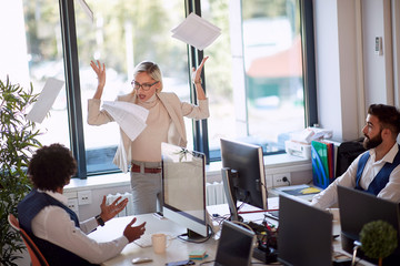 Businesswoman getting angry at a coworker. Businesswoman throwing the papers in rage.