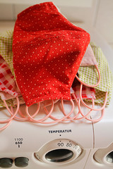 Selbstgenähte Masken, Schutzmasken liegen auf Haufen, als Schutz vor Corona, Covid-19, Viren, Smog, Luftverschmutzung, vor der Waschmaschine zur Wäsche bei 90 Grad Temperatur zur Desinfektion.