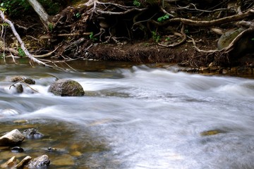Fototapeta na wymiar A river flowing with the rock inside