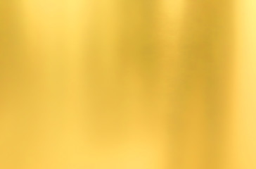 Gold wall texture background. Yellow shiny gold metal sheet surface with light reflection