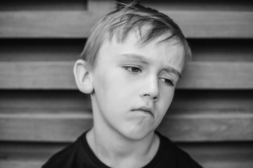 Unhappy lonely boy thinking about something. Boredom child.