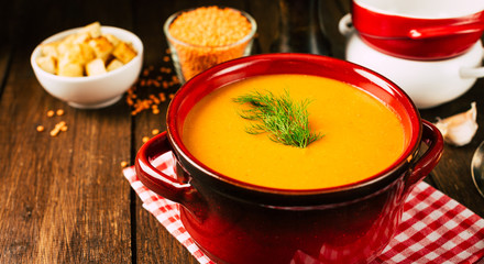 Lentil mashed soup in a pan, wooden background