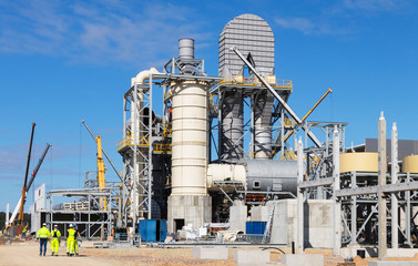 Cranes and lifting mechanisms are located at the construction site of a new plant