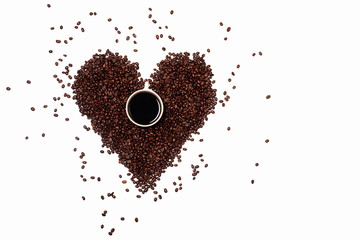 a handful of roasted coffee beans scattered in the shape of a heart. coffee heart with a Cup of coffee in the middle. a Cup of black coffee in an abstract on an empty white background