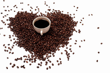 scattered coffee beans on a white empty background. heart-shaped coffee beans. a Cup of black coffee on a background of coffee beans. the Cup stands on a coffee handful in the shape of a heart