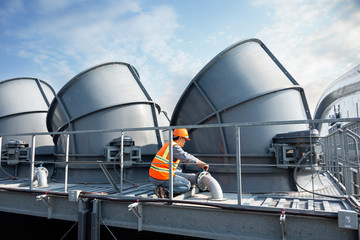 worker open valve  of cooling tower on blue sky background