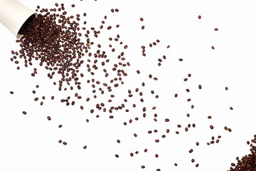 coffee beans were scattered across the entire area of the frame. coffee background of roasted brown beans. a white glass fell to the surface and spilled coffee beans on a white background