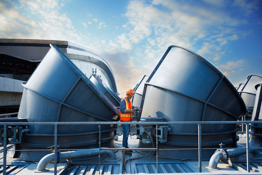 Worker Standing  Top Of Cooling Tower On Blue Sky Background