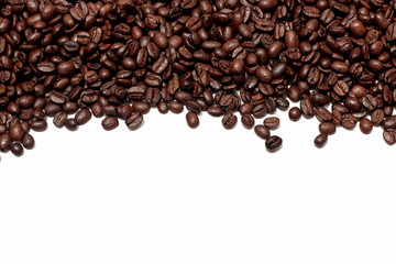 background of roasted brown coffee beans. the texture of coffee or abstraction for the background. a handful of coffee beans is placed on top along the edge of the frame, falling from above