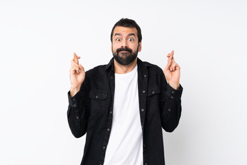 Fototapeta premium Young man with beard over isolated white background with fingers crossing and wishing the best