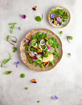 Delicious summer salad with edible flowers, vegetables, fruit, microgreens and cheese. Clean and healthy eating concept. Top view.