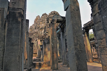 Mysterious Angkor. The ruins of an ancient palace. Many columns with drawings of apsara dancers form galleries without a ceiling. In the distance stands Bayonne Temple. UNESCO Heritage.