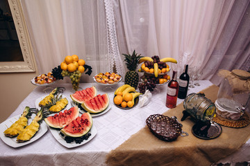 Dishes with berries and exotic fruits. Fruit salad. Dessert on the festive table.