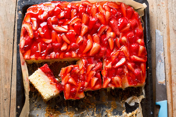 Sponge cake with lemon cream custard, strawberries and jelly, sliced
