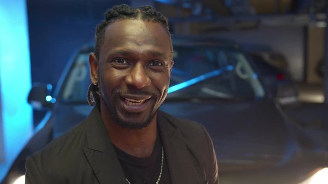 Black thug looks at the camera, smiles and speaks