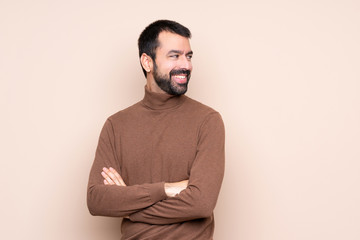 Man over isolated background with arms crossed and happy