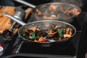 Chief in a restaurant cooking seafood with sauce