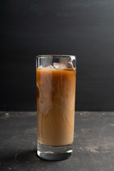Iced coffee with cream on the rustic background. Selective focus. Shallow depth of field.