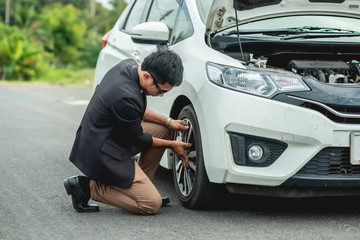 Man changing wheel after a car breakdown. Transportation, traveling concept © Wutthichai