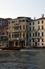 Fototapeta na wymiar Photo of Grand canal in Venice with historical facades made in baroque and renaissance styles with balustrades, piles, boats in sunny summer day.