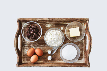 Ingredients for baking chocolate cake measured and arranged on the serving tray.