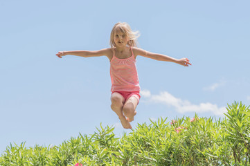 Happy crazy kid jumping on a trampoline, Summertime fun