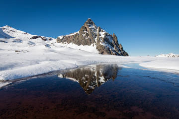 Frozen lake and snowy mountain on a sunny winter day. Anayet mountain, Huesca, spanish Pyrenees, Spain