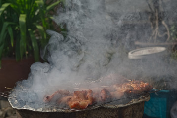Chicken stick set with smoke on a charcoal stove