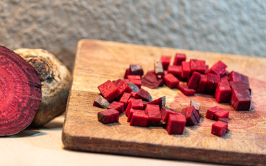 Beet (Beta vulgaris L.) chopped on a wooden board next to broken tubers