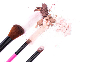 Makeup brushes with eye shadow on a white background