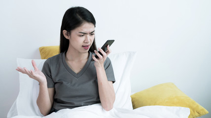 An Asian woman talking on a mobile phone with her friend or boyfriend, She was stressed and argued with the person she spoke with.