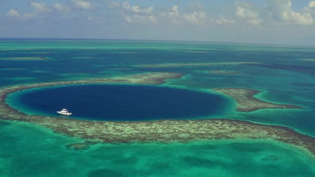 Aerial view of yacht in sea against cloudy sky, drone view of scenic marine seascape - Great Blue Hole, Belize