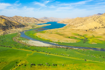 Aerial nature top view of Lake Kaweah Recreation Area outside of Sequoia National Park. Green grass, blue sky, yellow mountains, morning, blue water. Autumn landscape. California, USA