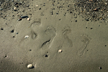 Two pairs of footprints on beach sand