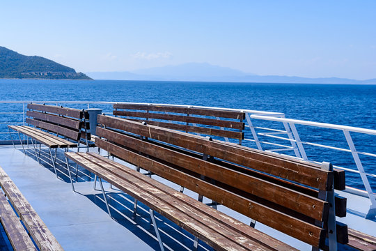 Free empty wooden seat on the deck of the ferry, Greece