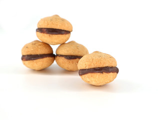 Baci di Dama, lady kisses translated into English, on white background. They are Italian biscuits made up of 2 shells of hazelnut paste combined with chocolate.