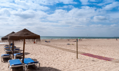Sun loungers and parasols prepared on the beach of Cadiz, Spain