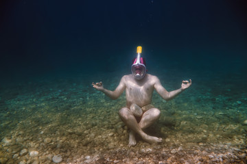 Snorkeler Is meditating, snorkeling man in full face mask, summer vacation activity, swimming in...