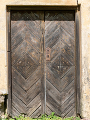an old wooden door in the wall of an old manor house