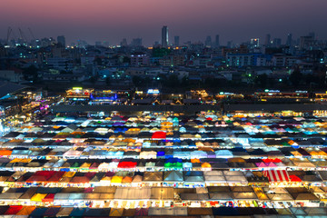 .02/02/2020 Bangkok, Thailand, Top view of Train Night Market Ratchada (Talad Rot Fai) flea market with plenty of shops with colorful canvas roofs near MRT line at night time in Bangkok
