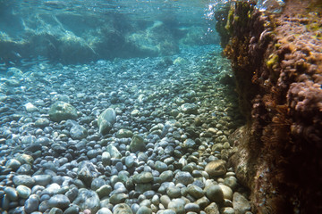 Underwater view of the Ieranto beach, in the southern Italy, Sorrento. The shot is takend during a sunny summer day, with rays of light coming inside the water. Amalfitana, Npoli coast