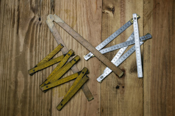 Folding rulers on wooden background