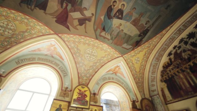 Arched windows, painted walls with the faces of saints and icons in the Orthodox church.