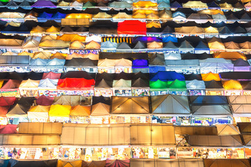 Bangkok, Thailand, Top view of Train Night Market Ratchada  flea market with plenty of shops with colourful canvas and amazing pattern of roofs near MRT line at nighttime in Bangkok