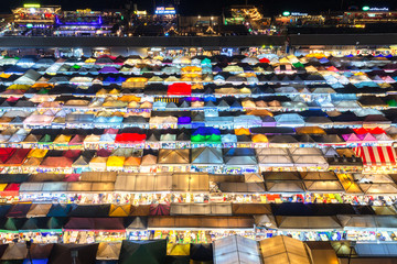 .02/02/2020 Bangkok, Thailand, Top view of Train Night Market Ratchada (Talad Rot Fai) flea market with plenty of shops with colorful canvas roofs near MRT line at night time in Bangkok