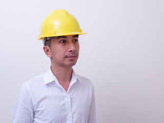 engineer with hands crossed wearing yellow helmet on white background