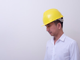 engineer with hands crossed wearing yellow helmet on white background